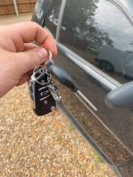 Hand with car keys by door – fast vehicle recovery and lockout support"